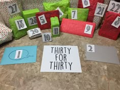 there are many wrapped presents on the floor with numbers and letters written on them to spell out thirty for thirty