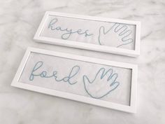 two framed pictures with handwritten words on them sitting on a marble counter top next to each other