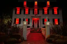 a large white house with red lights on it's windows