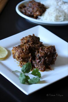 some food is on a white plate next to rice and lemon wedges with cilantro