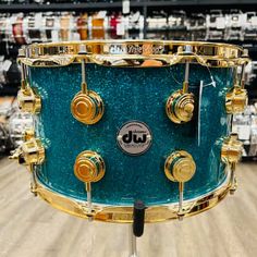 This Collector's Series snare features a Teal Glass Glitter, Gold Hardware, a SSC shell design with reinforcement rings, and DW's suite of high... Snare Drum, Glitter Glass, Music Gear, Gold Hardware, The Collector, Drums, Gold Rings, Shells, Glitter