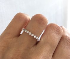 a woman's hand with a diamond ring on top of her finger, showing the band