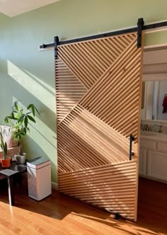 an open sliding door in a living room with wood flooring and green wall paint