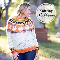 a woman wearing an orange and white knitted sweater with bears on it, standing in front of a cemetery