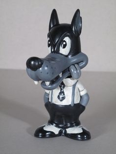 a black and white figurine with a dog on it's head wearing a tie