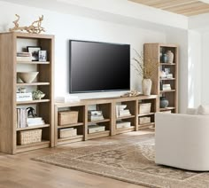 a large flat screen tv mounted on top of a wooden entertainment center in a living room