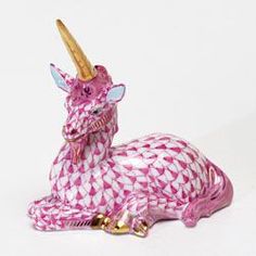 a pink and white dragon figurine sitting on top of a table