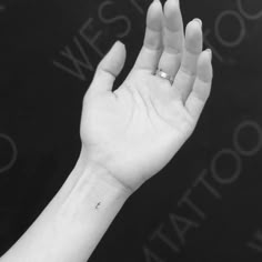 a person's hand with a small tattoo on the middle of their left wrist