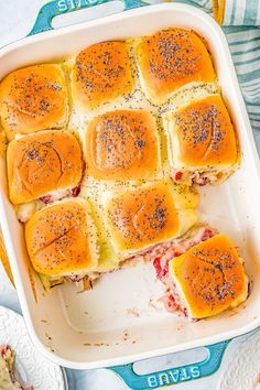 a casserole dish filled with sliders and cheese