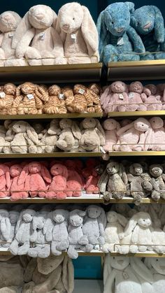 several rows of stuffed animals on display in a store