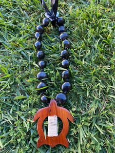 "18\" Wooden Turtle Pendant Black Kukui Nui Lei Necklace Beads:  Approximately 1 inch in diameter Each piece has a distinct character of its own, for no two are exactly alike in color, shape, and size. Hand-crafted, sanded and polished by Native artisans Adjustable Black Fine Satin Ribbon Tie" Black Beaded Necklaces With Round Pendant As Gift, Themed Black Jewelry As Gift, Themed Black Jewelry Gift, Adjustable Jewelry With Large Beads For Gifts, Spiritual Black Beads Jewelry, Black Beaded Necklace With Round Pendant For Gift, Pendant Jewelry With Large Beads As Gift, Themed Beaded Jewelry For Gifts, Round Pendant Necklace With Large Beads As Gift