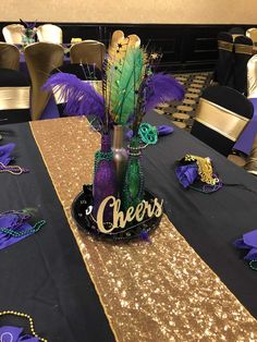 a table topped with purple and green decorations next to gold sequin tables cloths