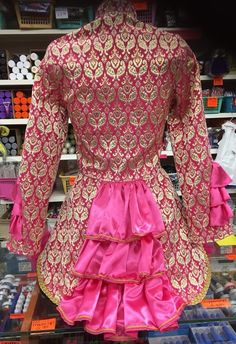 a pink and gold dress on display in a store