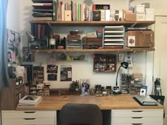 a desk with many books and other items on top of it in a home office