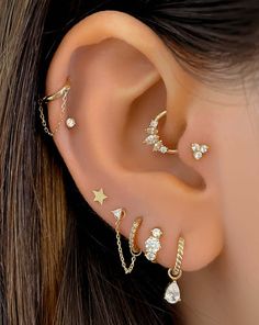 a woman's ear with five different types of piercings