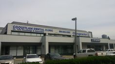 the front of a dental clinic with many cars parked in front of it and on the side of the road