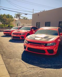 three red cars parked in front of a building