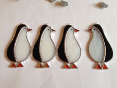 three pieces of art glass are sitting on a white tablecloth with silver and red accents