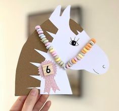 a hand holding up a card with a horse's head and number on it