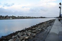 a large body of water sitting next to a sidewalk