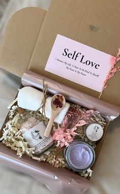 an open box containing various items such as candles, soaps and body scrubs