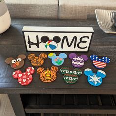 a table topped with lots of mickey mouse magnets on top of a wooden table