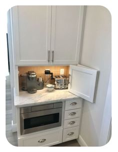 a kitchen with white cupboards and appliances in the corner, including an oven and microwave