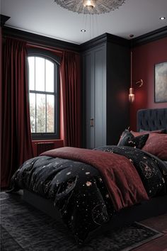 a bedroom with red walls, black bedding and a chandelier hanging from the ceiling