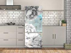 a kitchen scene with focus on the refrigerator and counter top, which has flowers painted on it