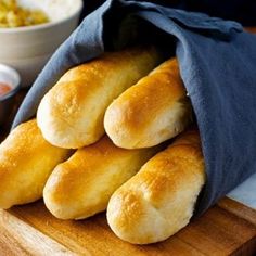 bread rolls sitting on top of a wooden cutting board