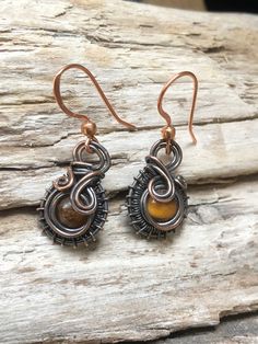 A 6mm round Tigers Eye bead that has been surrounded by woven copper wire and then suspended from copper ear wires.