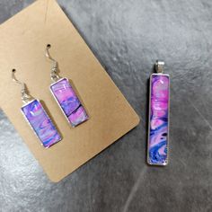 Beautiful hand painted rectangular shaped stainless steel pendant and matching earrings. It comes with an 18 inch leather like, adjustable  cord necklace  with lobster claw clasp. Purple Enamel Pendant Jewelry, Purple Jewelry Set, Handmade Purple Resin Necklace, Adjustable Hand-strung Purple Necklace, Artistic Purple Pendant Jewelry, Artistic Hand-painted Purple Earrings, Purple Jewelry, Stainless Steel Pendant, Cord Necklace