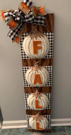 a wooden sign with pumpkins hanging from it's sides and the letter f on top