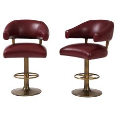 pair of burgundy leather bar stools with brass base and footrests for sale