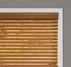 a cat sitting on top of a window sill in front of a blinds covering