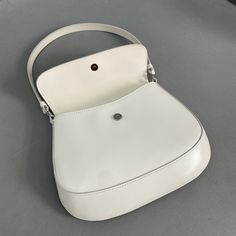 SHOP MORE LUXURY PRODUCTS HERE Description Prada Cleo Brushed Shoulder Bag With Flap White For Women, Women’s Bags 8.6in/22cm 1BD311_ZO6_F0009_V_OOO The Prada Cleo bag with sophisticated allure reinterprets an iconic design of the brand from the 1990’s. Sleek curved lines emphasized by the particular construction rounded on the bottom and sides give this flap bag a soft, light look. Brushed , a modern and versatile material that is distinctive in Prada collections, is ideal for creat White Leather Top Handle Baguette Bag, White Leather Baguette Bag With Top Handle, White Bag With Round Handle For Everyday Use, White Leather Saddle Bag For Daily Use, White Saddle Bag For Everyday Use, White Baguette Bag With Top Handle, White Rectangular Saddle Bag With Removable Pouch, Modern White Saddle Bag For Everyday Use, Designer White Bag With Round Handle