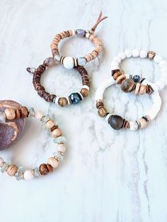 Earthy, natural, cozy, and everyday. Beautiful beige, white, cream, brown, and touches of sienna and rust in these mixed medium stack bracelets. Several gemstone varieties in different sizes, finishes, and colors. Several Jaspers, Tibetan Agate, Fossilized Coral, Picture Jasper rondelle, and many ethical bone beads in a variety of colors and shapes. Mix these in with recycled glass, Ebonywood, beads, Kente Krobe sand glass beads, shell, coconut disks, and mixed metals. Unique and stunning. Strung on heavy duty elastic. The item/s pictured is the item you will receive. Bracelets is 7.0" to 7.5" in length. HavSolStudio on ETSY | Mixed media . Earthy elegance . Great texture . Beach inspired . Coastal calm . A little rustic . Worldly . Alluring . Recycled glass . Reuse . Repurpose . Statement Everyday Hand Wrapped Brown Bracelets, Everyday Brown Hand-wrapped Bracelets, Everyday Brown Hand Wrapped Bracelets, Bohemian White Bracelets For Everyday, Rustic Brown Bracelet For Everyday Wear, Rustic Brown Bracelets For Everyday, Everyday Stackable Brown Jewelry, Everyday Brown Stackable Jewelry, Rustic Brown Everyday Bracelets