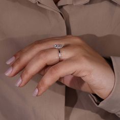 a woman's hand wearing a diamond ring