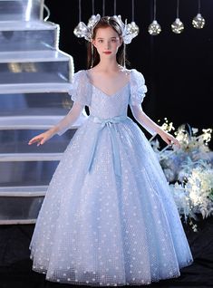 Journey through a fairy tale with this enchanting blue flower girl dress, designed to make any little girl feel like she’s stepped into a storybook. Does this gown not look like it’s woven from the very fabric of a magical night? The dress radiates a soft, serene glow with its pastel blue color and shimmering sequins scattered across the bodice, which are beautifully complemented by fluttery, sheer sleeves that add a dream-like quality. The flowing tulle skirt, dusted with silver sparkles, float Dream Daughter, Blue Flower Girl Dress, Blue Flower Girl, Pastel Blue Color, Flower Girl Dresses Blue, Tulle Balls, Magical Night, Flower Shorts, Blue Tulle