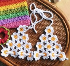 two crocheted earrings are sitting on a table next to a knitted bag