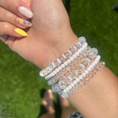 Adorn your arms with this stunning combination of white, crystal and gold-toned bracelets. Crafted to evoke a timeless elegance, these precious accessories are the perfect blend of minimalist sophistication and classic luxury. Material :* 4mm gold plated beads * charms * crystal beads *4mm matte beads • Bracelets are custom-crafted according to size; if the desired size isn't listed below, please contact me for assistance. • Processing Time is an estimated 3-5 business days (does not include wee Elegant White Beaded Stretch Bracelet, Dainty White Bracelet With Gold Beads, White Pearl Jewelry With Faceted Beads, Elegant Crystal Bracelet With Clear Round Beads, White Party Bracelets With Rhinestones, White Cubic Zirconia Crystal Bracelet For Party, White Rhinestone Bracelets For Party, Dainty White Stretch Bracelet With Gold Beads, Elegant White Crystal Bracelet With Spacer Beads