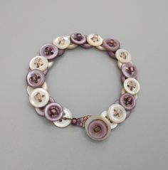 This handmade upcycled bracelet is made of shell buttons, some of which have been hand-dyed purple.  The shell buttons are then strung together using taupe-colored floss.  The closure is a button loop, and the bracelet is 7 inches long. Button Necklace, Shell Buttons, A Button, Necklace Etsy, Jewelry Bracelets, Mood Board, Shells, Beaded Bracelets, Bracelet