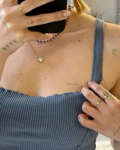 a woman with tattoos on her chest looking at her cell phone