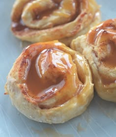 three pastry rolls covered in caramel sauce