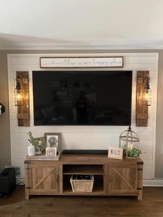 a flat screen tv mounted to the side of a wooden entertainment center in a living room