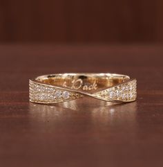 a close up of a gold ring on a wooden surface with the word love written in it