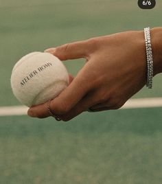 a tennis ball being held by a woman's hand with the name jefferson written on it