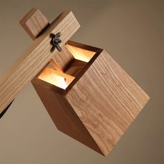 a wooden light fixture hanging from the side of a wall with two lights on it