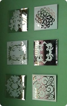 the wall is painted green with white paper cutouts on it, and there are many different designs