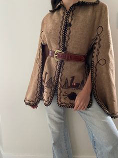 Rare find! Absolutely incredible cape adorned with expertly embroidered details. Warm and practical with slits for fluid arm movement.  No tag - fabric and brand unknown. Appears to be made of wool.  Will fit most. Model is a size small. In great condition with no notable flaws. Has been hand-washed. *Belt not included DISCOUNTS :  20% off orders of two or more items  (not applicable if already on sale). I will also do combined shipping- please message me before buying so I can arrange it. Pleas Beige Bohemian Winter Cape, Beige Wool Cape For Fall, One Size Cape For Fall Festival, Bohemian Shawl Cape For Fall, Brown Long Sleeve One-size Cape, Brown Long Sleeve Cape For Spring, Brown Long Sleeve Spring Cape, Oversized Fall Festival Cape, Brown Bohemian Cape Outerwear